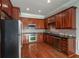 Galley kitchen with stainless steel appliances, granite countertops, and cherry wood cabinets at 2300 Peachford Rd # 3411, Dunwoody, GA 30338