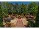 Spacious outdoor patio with multiple seating areas and a built-in brick grill, surrounded by mature trees and landscaping at 2300 Peachford Rd # 3411, Dunwoody, GA 30338