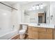 Clean bathroom with white tile, large mirror, wood vanity, and a shower-tub combo at 328 Bentley Pl # 328, Tucker, GA 30084