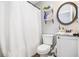 Cozy bathroom with a toilet, vanity, round mirror, and shower curtain at 569 Lovell Rd, Temple, GA 30179