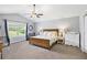 Bright bedroom with a ceiling fan, vaulted ceiling, carpet floors, and natural light from a large window at 569 Lovell Rd, Temple, GA 30179