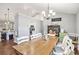 Spacious dining room featuring a rustic wooden table, chandelier, and view into the modern kitchen at 569 Lovell Rd, Temple, GA 30179
