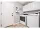 Functional laundry room featuring a modern washer and dryer, cabinets and tile flooring at 569 Lovell Rd, Temple, GA 30179
