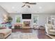 Well-lit living room with a stone fireplace, hardwood floors, and large windows showcasing a comfortable living space at 569 Lovell Rd, Temple, GA 30179