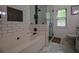 Well-lit bathroom featuring a modern tub, glass shower, white subway tile, and elegant fixtures at 7113 Silver Mine Xing, Austell, GA 30168