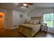 This bedroom features a high ceiling, wood floors, a ceiling fan, a bed, and a window that provides natural light at 7113 Silver Mine Xing, Austell, GA 30168