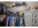 Organized walk-in closet with hanging clothes, folded items, drawers, and shelves for optimal storage at 7113 Silver Mine Xing, Austell, GA 30168