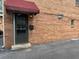 Apartment entry featuring a dark door with a maroon awning and brick facade at 1233 Woodland Ne Ave # 5, Atlanta, GA 30324