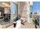 Outdoor balcony with seating area offering city views through the sliding glass doors to the interior at 285 Centennial Olympic Park Nw Dr # Ph2-7, Atlanta, GA 30313