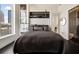 Well-lit bedroom with modern decor, city views, and an attached bathroom with sliding glass doors at 285 Centennial Olympic Park Nw Dr # Ph2-7, Atlanta, GA 30313