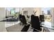 Bright dining room with city views, a modern glass table, and stylish black chairs with a matching area rug at 285 Centennial Olympic Park Nw Dr # Ph2-7, Atlanta, GA 30313