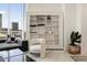 Comfortable living area with a unique built-in bookshelf, modern furniture, and city views from a large window at 285 Centennial Olympic Park Nw Dr # Ph2-7, Atlanta, GA 30313