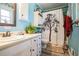 The blue bathroom has a vanity with a sink and shower with patterned curtain creating a charming and functional space at 315 Charlotte Blvd, Stockbridge, GA 30281