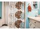 A clean and functional bathroom, complete with a toilet, vanity, and a shower with a decorative floral-patterned curtain at 315 Charlotte Blvd, Stockbridge, GA 30281