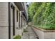 Exterior side view of the townhome with brick facade, lush landscaping, and a paved walkway at 574 Boulevard Ne Pl # 4, Atlanta, GA 30308