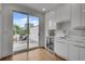 Modern kitchen with white cabinets, wine fridge, stone backsplash, and terrace access at 574 Boulevard Ne Pl # 4, Atlanta, GA 30308