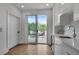 Modern kitchenette with white cabinets, wine fridge, stone backsplash, and terrace access at 574 Boulevard Ne Pl # 4, Atlanta, GA 30308