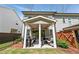 Covered backyard patio with outdoor seating and a ceiling fan offers comfortable outdoor living at 116 Birch Tree Way, Cumming, GA 30040