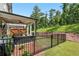 Beautiful backyard with a cozy covered patio, enclosed by a sleek black metal fence at 116 Birch Tree Way, Cumming, GA 30040