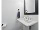 Modern pedestal sink with black framed mirror and neutral walls offers a clean design at 116 Birch Tree Way, Cumming, GA 30040