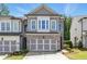 Charming two-story townhome featuring a brick facade, two-car garage, and well-manicured lawn in a desirable neighborhood at 116 Birch Tree Way, Cumming, GA 30040