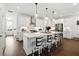 Elegant kitchen with white cabinets, a spacious island with seating, and hardwood floors, perfect for entertaining guests at 116 Birch Tree Way, Cumming, GA 30040
