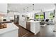 Open-concept kitchen with white cabinets, stainless steel appliances, a large island, and seamless flow to the living area at 116 Birch Tree Way, Cumming, GA 30040