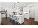 Well-lit kitchen with white cabinets, a central island with bar stools, and hardwood floors, blending style and functionality at 116 Birch Tree Way, Cumming, GA 30040