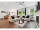 Bright living room with hardwood floors and a sliding glass door to the backyard, complemented by a stone fireplace at 116 Birch Tree Way, Cumming, GA 30040