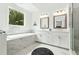 Luxurious main bathroom with double vanity, soaking tub, and a window overlooking the greenery at 116 Birch Tree Way, Cumming, GA 30040