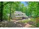 Lush backyard featuring a well-maintained lawn, mature trees, and a charming firepit area at 3870 Windhurst Dr, Lilburn, GA 30047