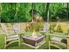 Relaxing backyard with a fire pit, chairs, a lush green lawn, and a charming playhouse at 3870 Windhurst Dr, Lilburn, GA 30047