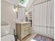 Bathroom featuring modern vanity, mirror, tile floor, skylight and shower at 3870 Windhurst Dr, Lilburn, GA 30047