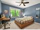 Blue bedroom features a ceiling fan, window with natural light and a desk with computer at 3870 Windhurst Dr, Lilburn, GA 30047