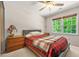 Bedroom features a ceiling fan, window with exterior views and a side table with lamp at 3870 Windhurst Dr, Lilburn, GA 30047