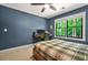Blue bedroom featuring a large window with natural light and a desk with computer equipment at 3870 Windhurst Dr, Lilburn, GA 30047