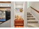 Hallway to stairs featuring a convenient storage bench, coat hooks, and a sunny window at 3870 Windhurst Dr, Lilburn, GA 30047