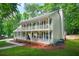 Classic two-story home with a double balcony, traditional columns, and a well-manicured front lawn at 3870 Windhurst Dr, Lilburn, GA 30047