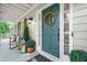 Inviting front entrance with a green door, lantern, and rocking chair at 3870 Windhurst Dr, Lilburn, GA 30047
