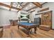 Entertaining game room with a pool table, media area, barn door, wooden beams, and stylish decor at 3870 Windhurst Dr, Lilburn, GA 30047