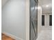 Hallway with carpet, wood look floors, and white floral wallpaper leads to a grey barn door at 3870 Windhurst Dr, Lilburn, GA 30047