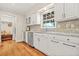 Bright kitchen featuring white cabinets, stainless steel appliances, and decorative backsplash at 3870 Windhurst Dr, Lilburn, GA 30047