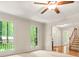Living room with hardwood floors, staircase, and large windows with nature views at 3870 Windhurst Dr, Lilburn, GA 30047