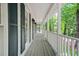 Inviting covered front porch featuring a classic white railing and charming dark green shutters at 3870 Windhurst Dr, Lilburn, GA 30047