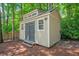 The charming backyard shed with double doors and a neutral color provides extra storage or workshop space at 3870 Windhurst Dr, Lilburn, GA 30047