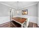 Cozy dining room features modern chandelier, wainscoting, wood-look flooring, and a lovely piece of art at 3924 Lorien Nw Way, Kennesaw, GA 30152
