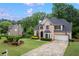 Beautiful brick home with a spacious driveway, lush green lawn, and mature trees at 3924 Lorien Nw Way, Kennesaw, GA 30152
