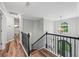 Upstairs landing featuring a black wrought iron banister, wood-look floors, and natural light at 3924 Lorien Nw Way, Kennesaw, GA 30152