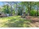 A vast, grassy backyard includes a wooden playset and access to the back deck at 1301 Eastridge Sw Rd, Atlanta, GA 30311