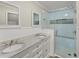 Bright bathroom featuring double sinks, granite countertop, and glass enclosed shower at 1301 Eastridge Sw Rd, Atlanta, GA 30311